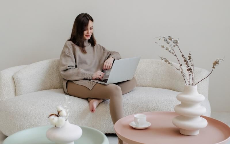 a person sitting on a couch with a laptop