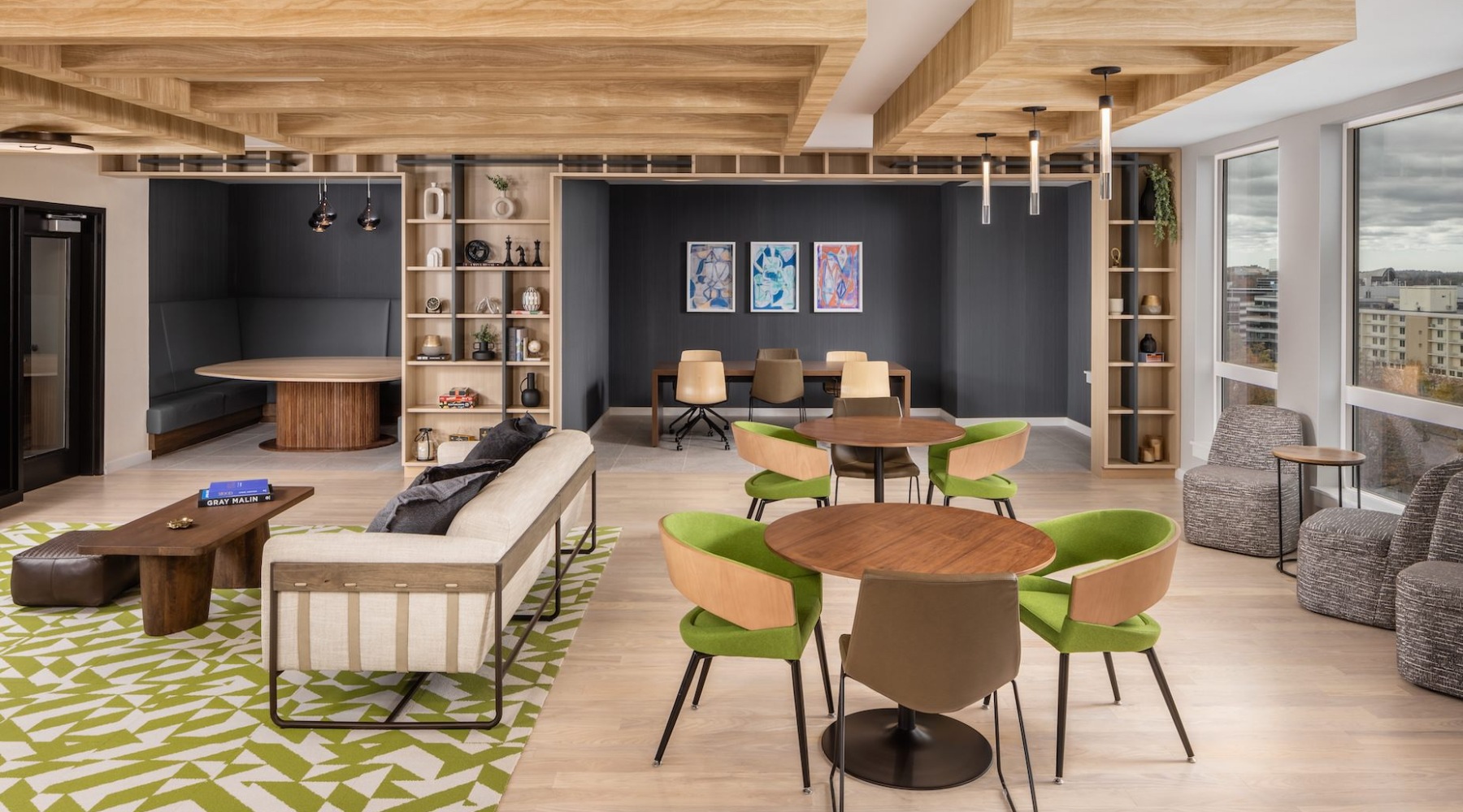 Resident lounge at The 305 apartments in Waltham, MA, featuring wood grain floor paneling and tables.